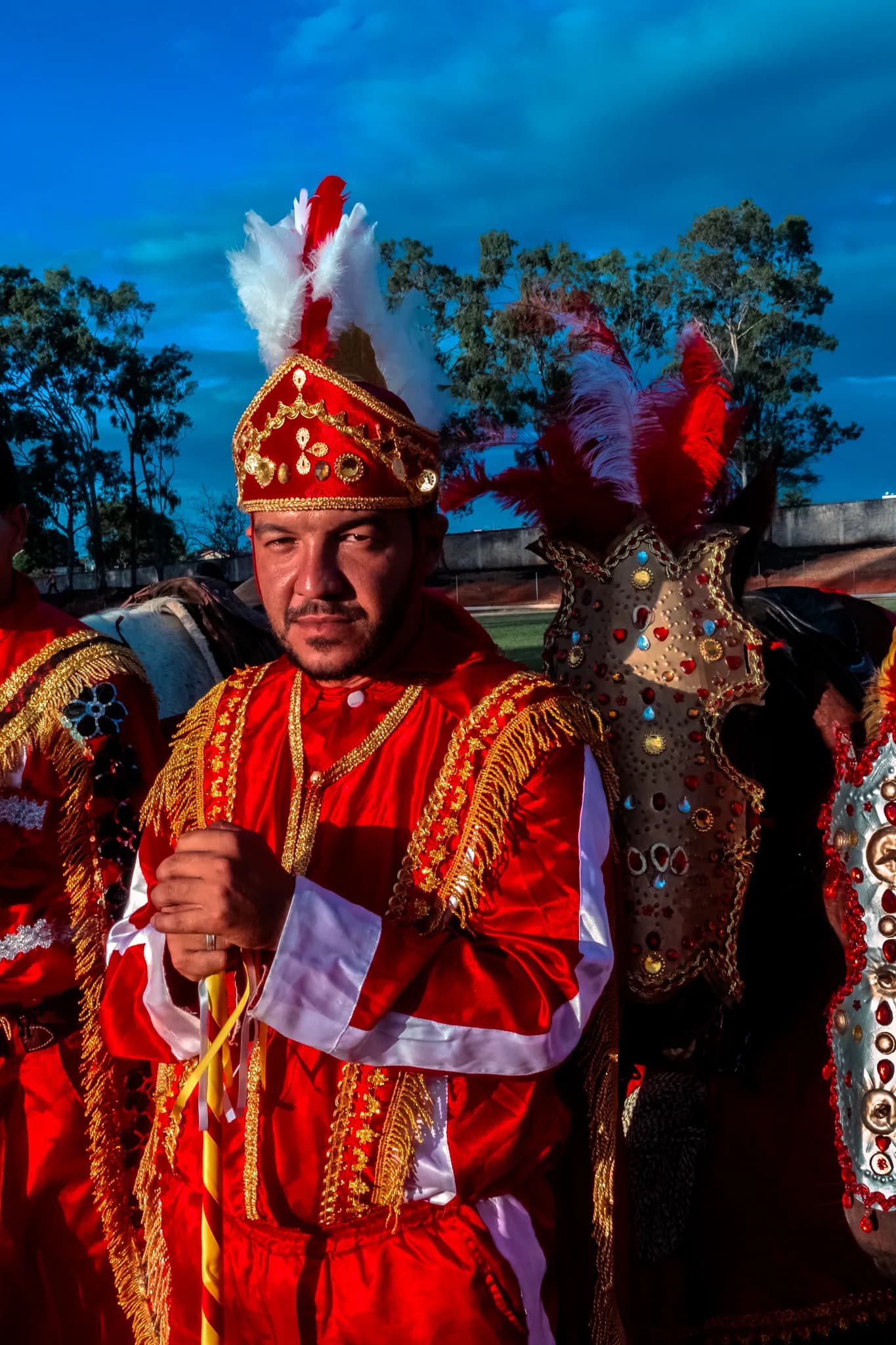 A group of Christian riders in red, standing together before the charge.