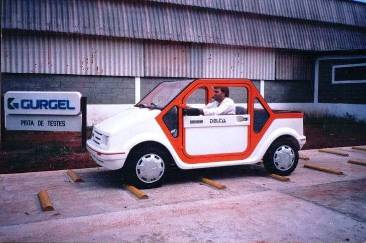 The Gurgel test track hall, a car raised on blocks under the factory sign.