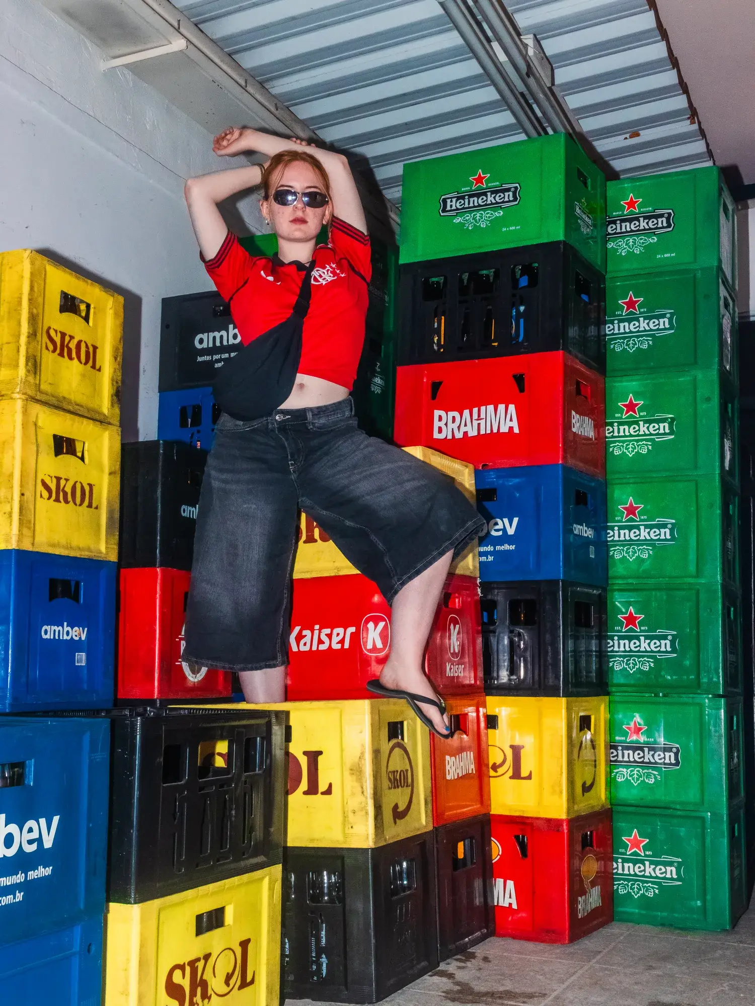A guest sitting on a stack of coloured beer crates in the storeroom.